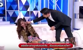 Nữ người mẫu Thippawan "Pui" Chaphupuang sợ hãi khi người dẫn chương trình đưa một chiếc vòng cổ có hình Phật lại gần. Ảnh chụp màn hình.