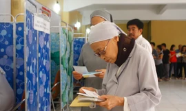 Dù đeo đai giữ đốt sống cổ, già yếu, đi lại khó khăn nhưng xơ Liên vẫn quyết tâm đến điểm bỏ phiếu để thực hiện quyền bầu cử.