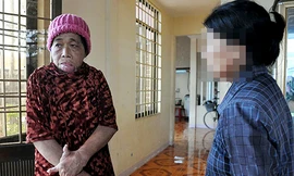 Những vết thâm tím còn hằn trên khuôn mặt của bà Chín (trái) do bị con đánh đập