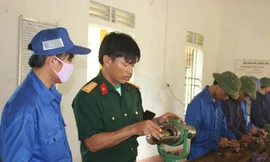 Thượng úy Đậu Bá Xuân (thứ 2, trái sang) đang hướng dẫn tổ sửa chữa ứng dụng sáng kiến mới