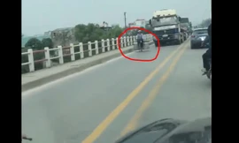 Người phụ nữ đạp xe thong dong trước đoàn ùn tắc xe tải, xe khách