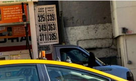  Một tài xế taxi đeo găng tay cao su vào đổ xăng trong khi giá xăng đã giảm do Covid-19 tại New York, Mỹ, ngày 14/3. Ảnh: Getty 