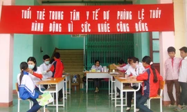 Nhân viên y tế tại Trung tâm y tế huyện Lệ Thủy khám bệnh cho học sinh ảnh: PV