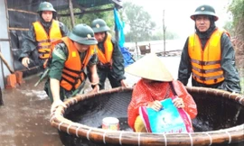 BĐBP TT-Huế dùng thuyền di chuyển dân vượt qua vùng nước sâu tại Huế ẢNH: P.V  