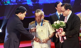 Bí thư Thành ủy Hoàng Trung Hải và Chủ tịch UBND TP Nguyễn Đức Chung trao danh hiệu công dân Thủ đô ưu tú cho anh hùng La Văn Cầu. Ảnh: Vietnamnet