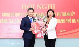 Phó Bí thư Thường trực Thành ủy Nguyễn Thị Tuyến trao quyết định của Ban Thường vụ Thành ủy và tặng hoa chúc mừng ông Nguyễn Phi Thường.