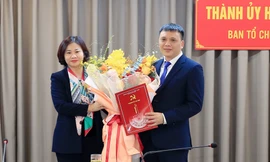 Phó Bí thư Thường trực Thành ủy Hà Nội Nguyễn Thị Tuyến trao quyết định của Ban Thường vụ Thành ủy và tặng hoa chúc mừng ông Nguyễn Minh Long