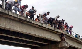 Người hiếu kỳ đứng xem chật kín trên cầu Tân Hạnh và hai bên bờ sông.