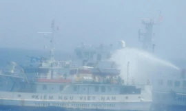 Tàu Trung Quốc vây hãm và phun nước vào tàu kiểm ngư Việt Nam. (Ảnh: Văn Sơn/TTXVN)