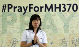 Một phụ nữ ở ngoại ô Kuala Lumpur cầu nguyện cho những người mất tích trên chuyến bay MH370. Ảnh: Reuters