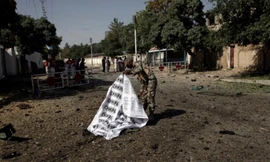 Một binh sĩ dùng bạt che thi thể nạn nhân trong vụ đánh bom ở Quetta. Ảnh: Reuters