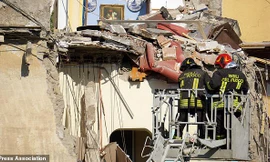 Hai lính cứu hỏa làm việc tại hiện trường vụ sập nhà. Ảnh: AP