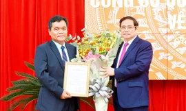 Đồng chí Phạm Minh Chính trao quyết định và chúc mừng đồng chí Hồ Văn Niên.