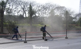 Dùng máy thổi bụi tại khu vực thi công ở đại lộ Thăng Long. Ảnh: Trường Phong