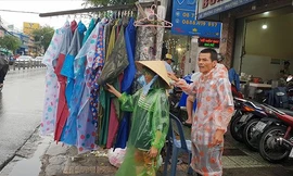 Hiệp sĩ Trần Văn Hoàng phụ vợ bán hàng rong trên phố Ảnh: Văn Minh 