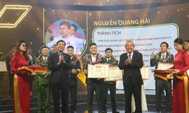 Phó Thủ tướng thường trực Trương Hòa Bình và Bí thư thứ nhất T.Ư Đoàn Lê Quốc Phong trao tặng Bằng khen và cúp cho cầu thủ Nguyễn Quang Hải Ảnh: Như Ý 