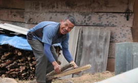 Ông Lầu Bá Hềnh chẻ củi dự trữ 