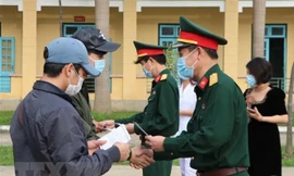 Trao giấy chứng nhận hoàn thành thời gian cách ly cho công dân Ảnh: TTXVN 