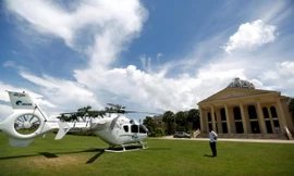 Một người đàn ông đứng cạnh chiếc trực thăng của UDG đậu trước một casino của khách sạn Dara Sakor ở Botum Sakor, tỉnh Koh Kong, Campuchia, tháng 6/2018 ảnh: Reuters 