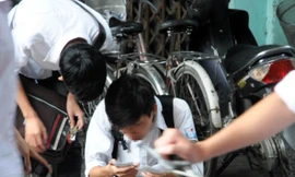 Hai thí sinh hồn nhiên mở phao thi xem lại kết quả trước trường THPT Hoài Đức A