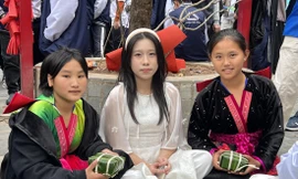 Giàng Thị Hờ (ngoài cùng bên phải) và Giàng Thu Hà (ngoài cùng bên trái) khoe ảnh gói bánh chưng cùng học sinh Hà Nội