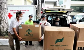 Nhà báo Đại Dương (trái) đại diện báo Tiền Phong cùng Tổng công ty Điện lực miền Nam hỗ trợ trang thiết bị y tế cho Bệnh viện Chợ Rẫy trong những ngày cao điểm chống dịch