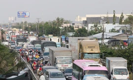 Quốc lộ 1 đoạn qua huyện Cái Bè (Tiền Giang) thường xuyên ùn tắc giao thông vào giờ cao điểm do xe container, xe tải nặng chở hàng hóa nông sản, lúa gạo lên TPHCM. Ảnh: Nhật Huy