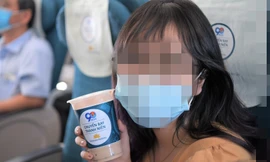 Hành khách trẻ thích thú với sản phẩm trà sữa trên chuyến bay. Ảnh: VNA