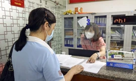 Cán bộ phường Trần Hưng Đạo (Hoàn Kiếm) tiếp dân, giải quyết thủ tục cấp giấy đi đường trong đợt giãn cách xã hội vừa qua. Ảnh: HOÀNG MẠNH THẮNG 