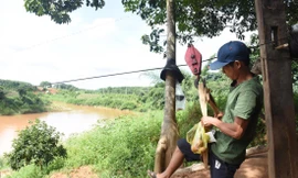 Người dân liều mình đu qua sông trên sợi dây cáp 