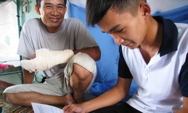 Ông Ơm và con trai xem lại kết quả bài thi môn cuối, trước khi rời Đà Nẵng. Ảnh: Nguyễn Huy