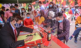 Ông đồ đeo khẩu trang, cho chữ qua tấm chắn ngày đầu năm mới