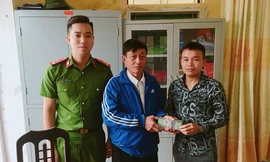 Anh Lương Văn Phú (bìa phải) trả lại 38 triệu đồng đã nhặt được trên đường cho ông Bùi Xuân Hỗ - Ảnh: Hoàng Long