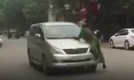 Lái xe bất chấp trên nắm ca pô có người vẫn nổ máy bỏ chạy - Ảnh: Cắt từ clip