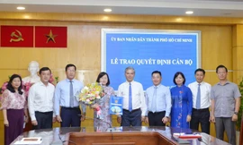 Phó Chủ tịch UBND TPHCM - Ngô Minh Châu trao quyết định cho bà Võ Thị Chính. Ảnh Thành uỷ TPHCM