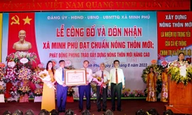 Đại diện Đảng bộ, chính quyền và nhân dân xã Minh Phú đón bằng công nhận đạt chuẩn nông thôn mới.