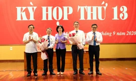 Phó Chủ tịch HĐND thành phố Phùng Thị Hồng Hà tặng hoa chúc mừng các đồng chí lãnh đạo huyện Mê Linh. Ảnh: Hoàng Sơn.