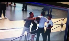 Hai hành khách cùng hành hung nhân viên nữ (người đàn ông ở giữa là nhân viên hàng không đứng ra can ngăn)