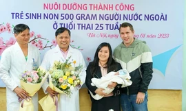 PGS.TS Trần Danh Cường (áo trắng ở giữa) cùng vợ chồng sản phụ Bùi Ngọc Dung và em bé sinh non. Ảnh: H.Minh