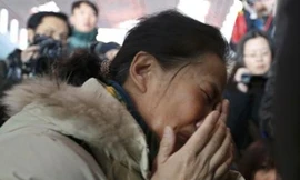 Người thân của một hành khách trên chuyến bay MH370 ôm mặt khóc trong lúc chờ đợi thông tin ở sân bay quốc tế Bắc Kinh. Ảnh: Reuters.