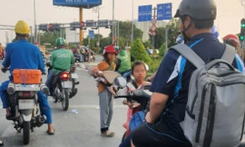 Các bé gái xin tiền người đi đường tại giao lộ Võ Văn Kiệt - An Dương Vương. Ảnh: Hoàng Thuận