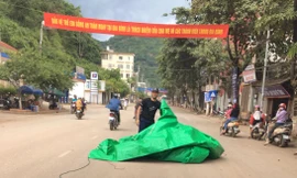 Bạt bay từ nóc ô tô tải trùm gọn anh chàng đi xe máy