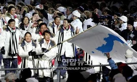 Lee Bo-ra (trái) và Han Jong-in cầm cờ trong lễ khai mạc Olympic Mùa đông 2006 ở Turin (Ý). Ảnh: Yonhap