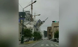 Người đi bộ chạy tán loạn khi một phần khách sạn đổ sập xuống đường. 