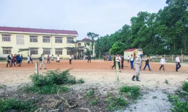 Nhân viên Đội xử lý bom mìn lưu động số 4 hướng dẫn các em học sinh di chuyển đến nơi an toàn. Ảnh: Kim Chiến.