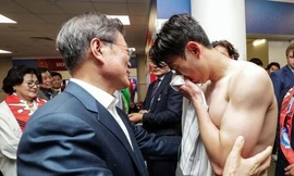 Tổng thống Hàn Quốc Moon Jae-in (trái) an ủi các cầu thủ đội nhà trong phòng thay đồ tại sân vận động Rostov-on-Don (Nga). Ảnh: Yonhap