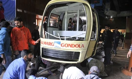 Cabin cáp treo rơi xuống đất sau khi bị cây thông đổ đè trúng. Ảnh: EPA