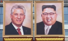 Tranh chân dung của ông Kim Jong-un được treo cạnh tranh chân dung Chủ tịch Cuba Miguel Diaz-Canel. Bức tranh vẽ ông Kim cười tươi trong bộ vest mang phong cách phương Tây. Ảnh: KCTV