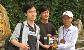 Nhân viên BQL khu du lịch thắng cảnh Ngũ Hành Sơn trao chiếc ví cho anh Lee Seung Hyeor, du khách người Hàn Quốc để quên trước đó.