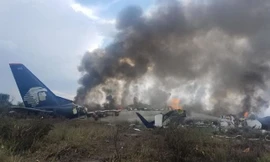 Máy bay bốc cháy sau khi trượt dài trên đường. Ảnh: AFP